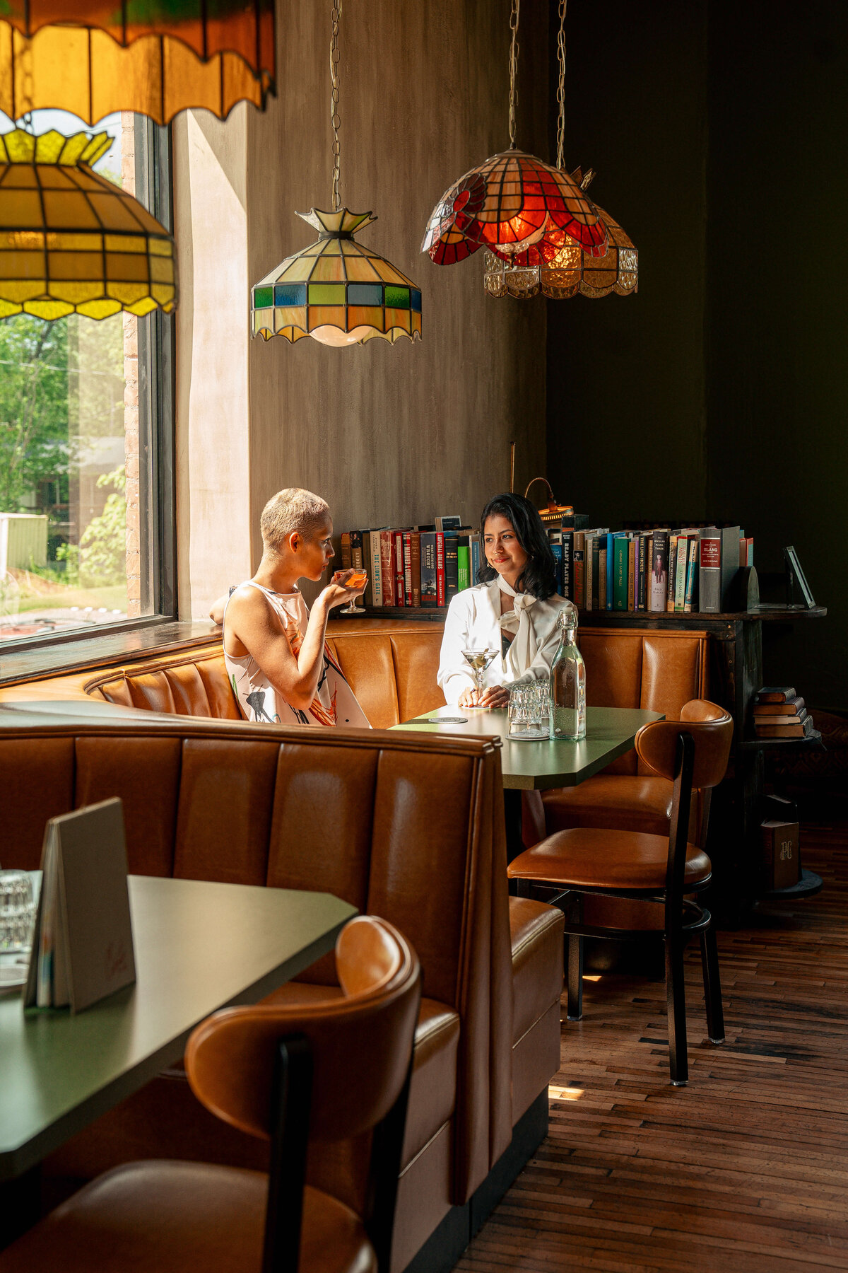 Hospitality photography in Asheville, NC featuring two people sipping on cocktails.