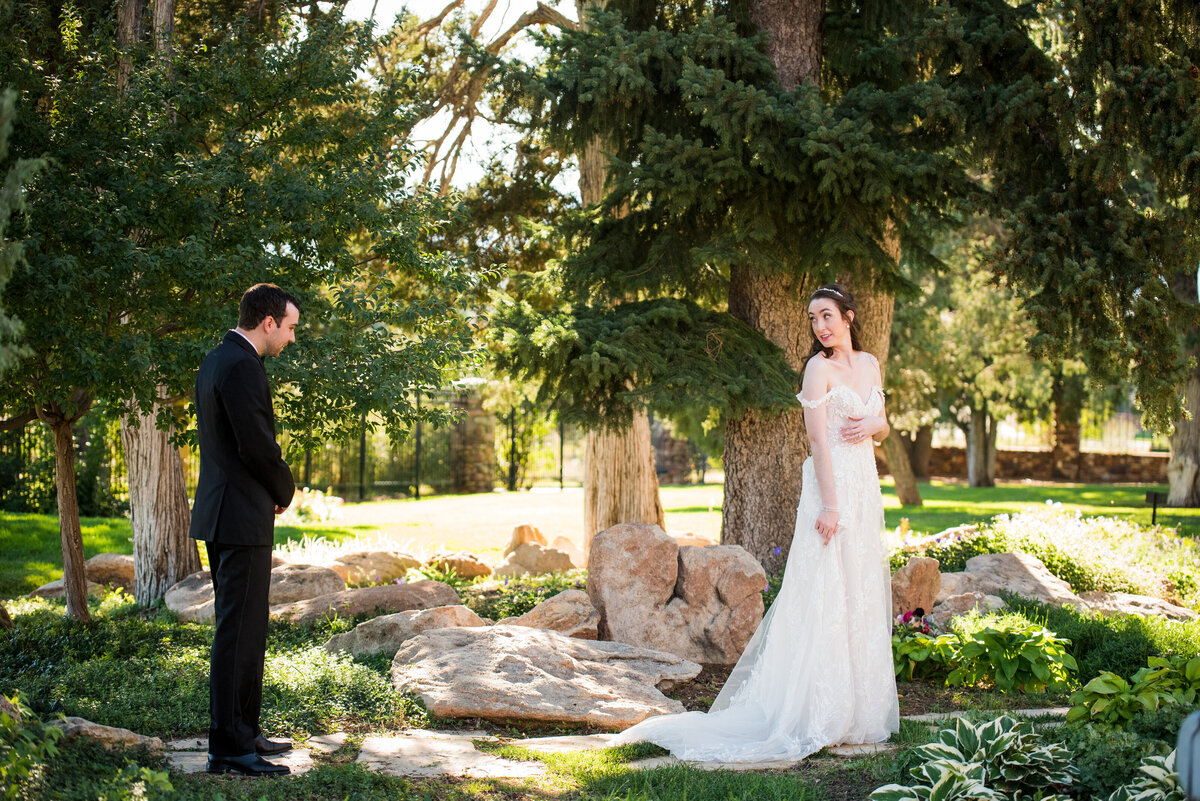 A groom admires the train of his bride's dress during their first look, captured by Colorado wedding photographer, Casey Van Horn.