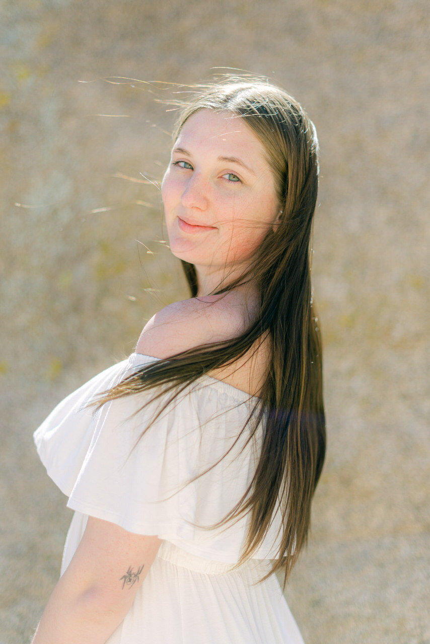 A luminous portrait of a woman in an off-the-shoulder white dress, captured in a refined editorial style by Elizabeth Kane Photography—serving Philadelphia, New York, and DC.