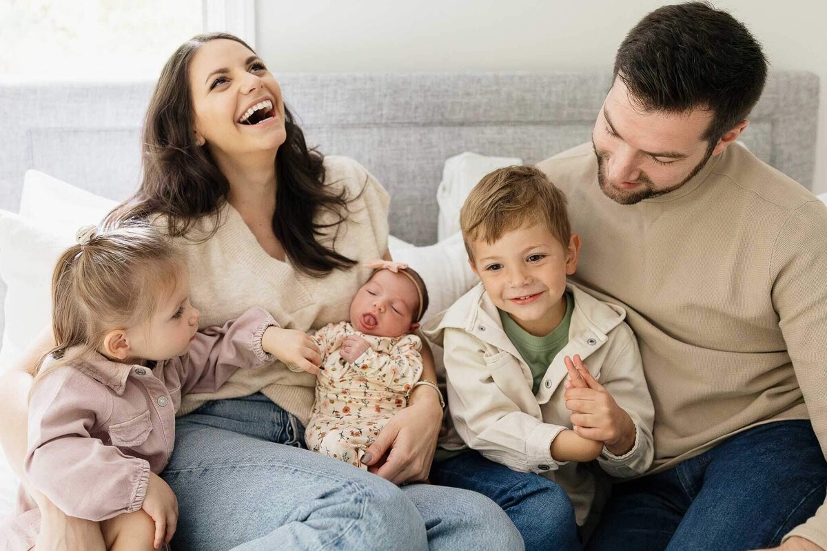 A family embraces their new baby during a lifestyle newborn photography session in Cleveland.