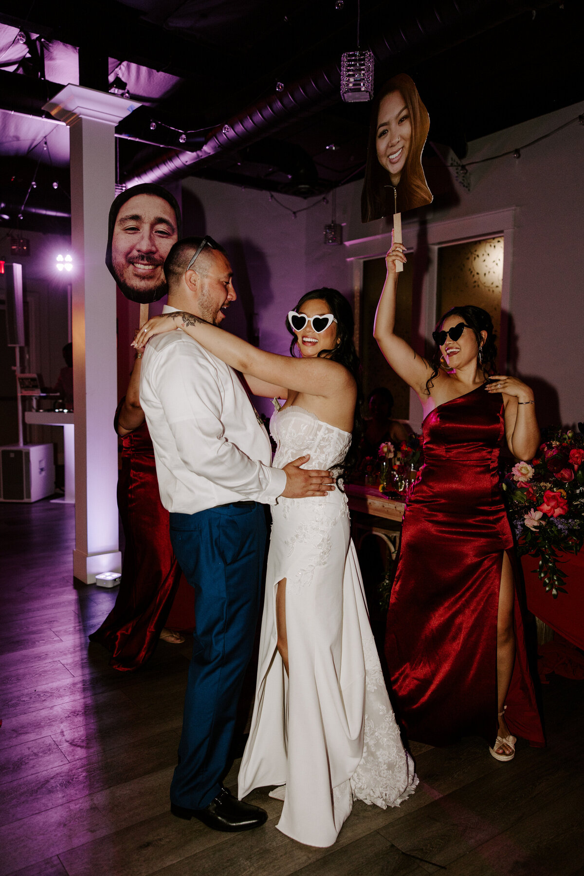 Two people smile and hold each other on the dance floor on their wedding day.
