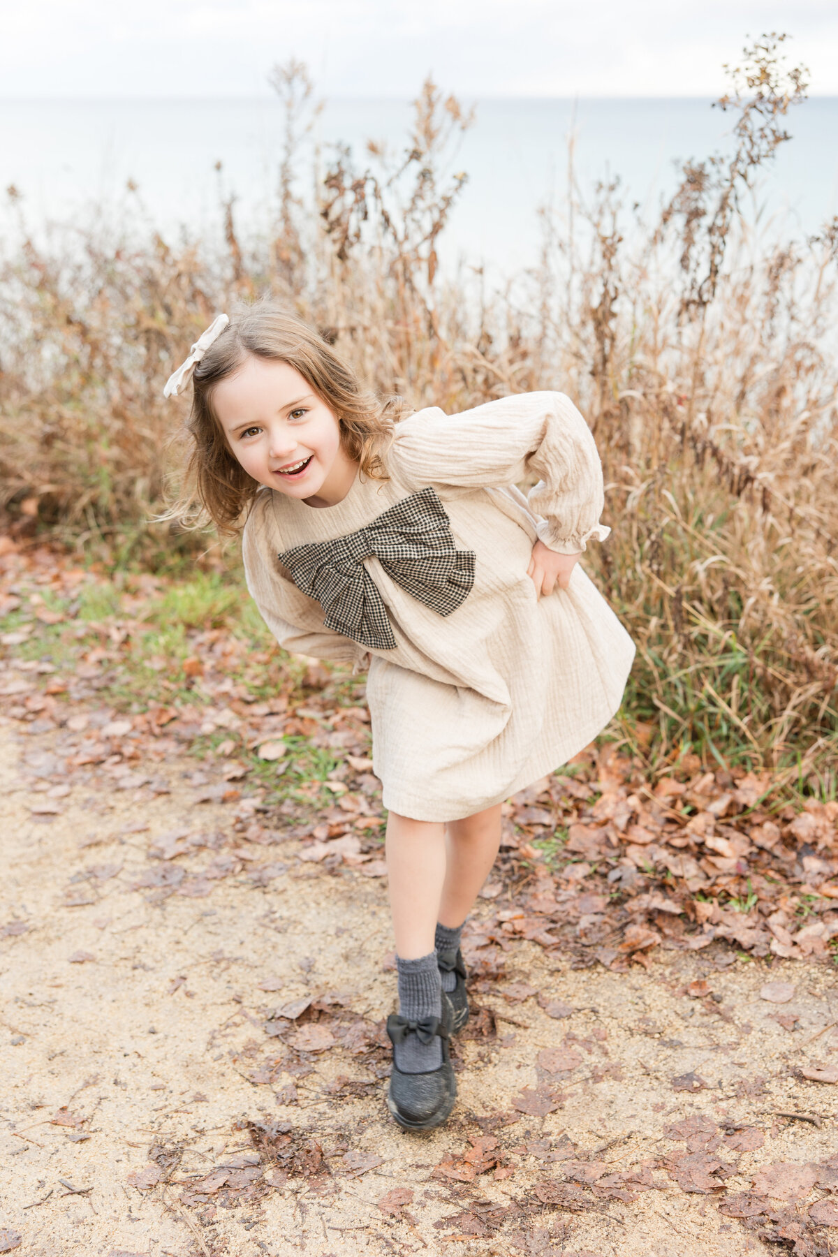A little girl with her hands on her hips and smiling