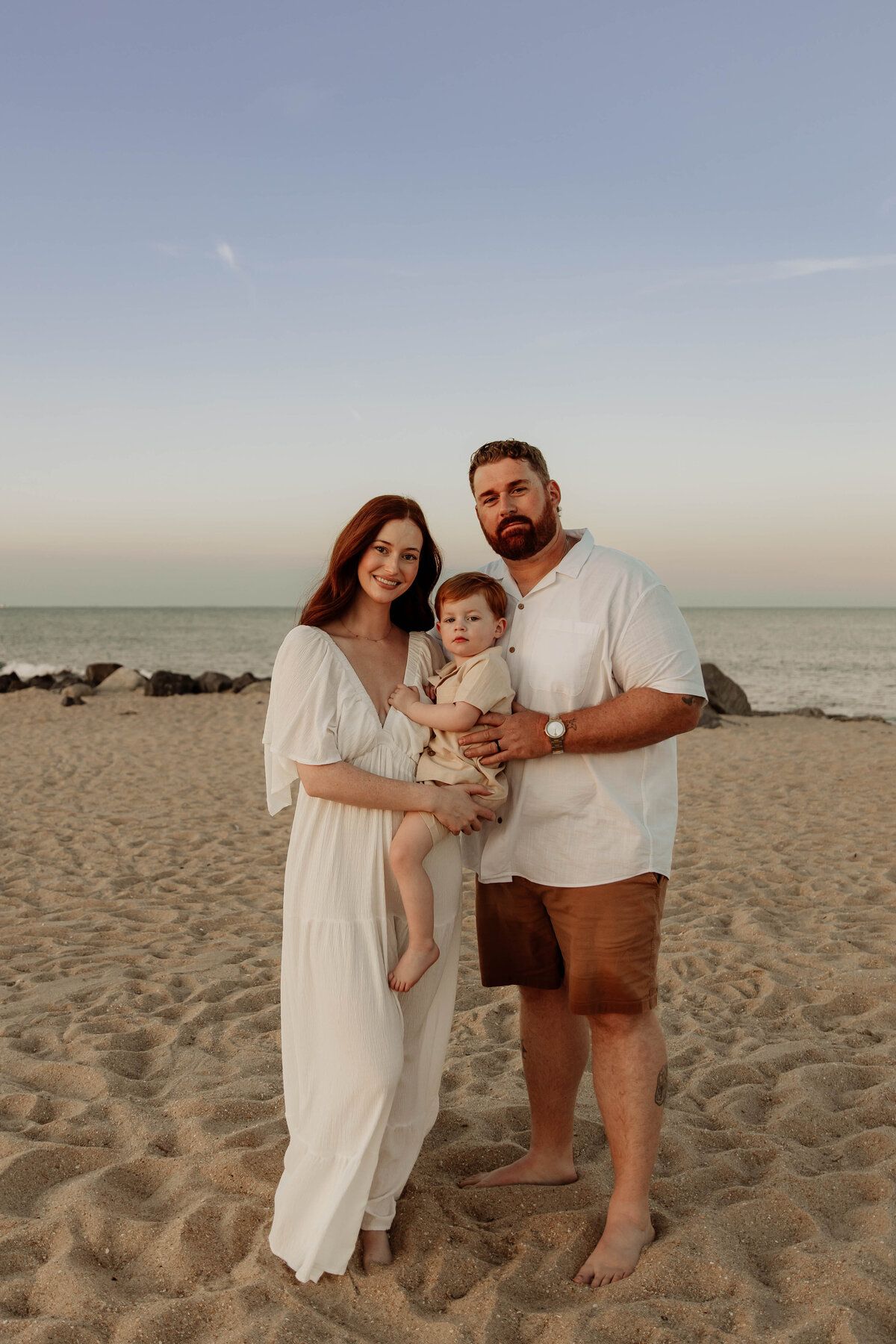 a family posing for a photo iat Sandy Hook  Beach in NJ
