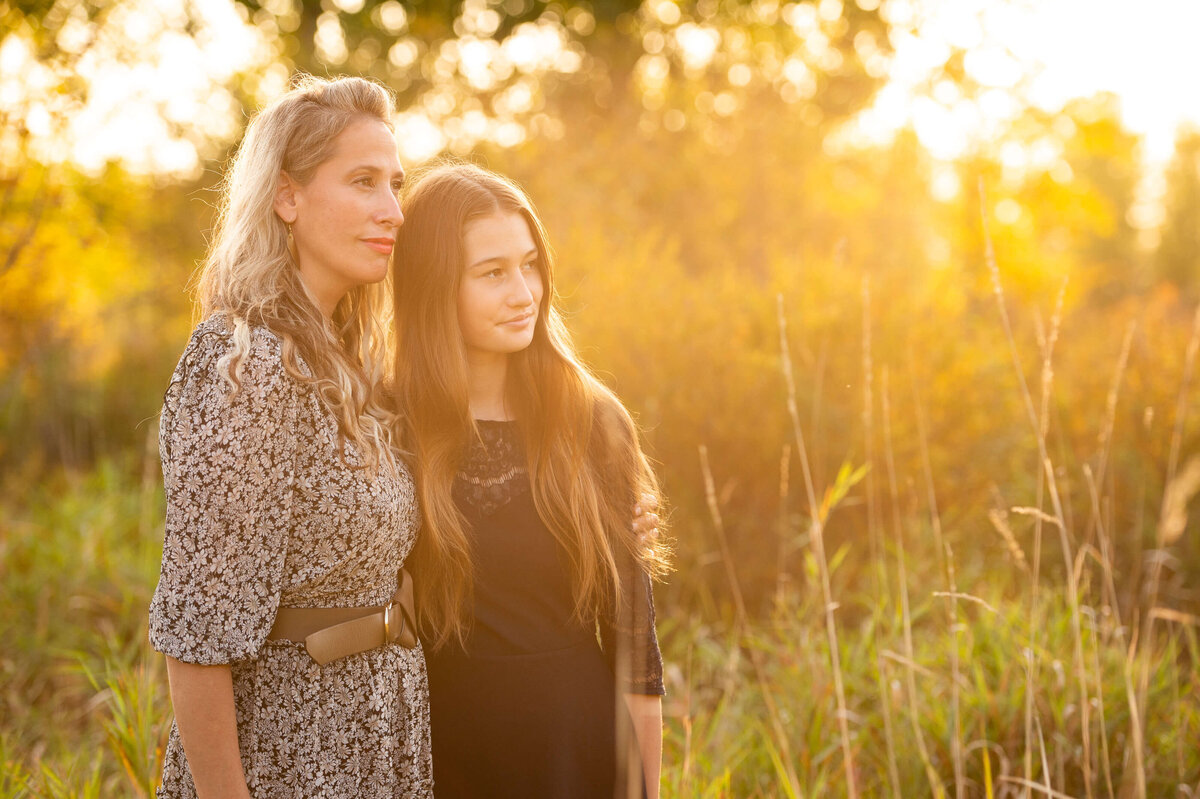 a mother and daughter hug and look at the sunset .  Taken by Ottawa family photographer JEMMAN Photography