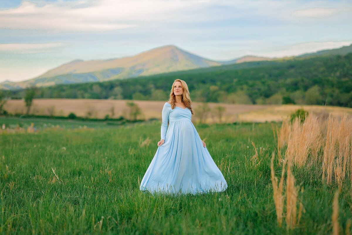Woman in blue maternity dress with mountains Harrisonburg VA