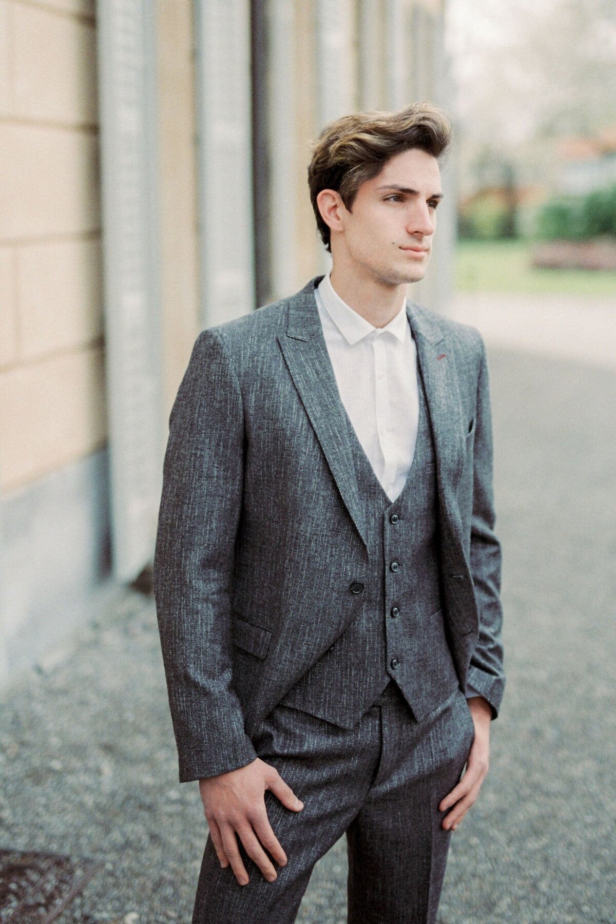 man-gray-suit-stands-near-old-villa-como-italy