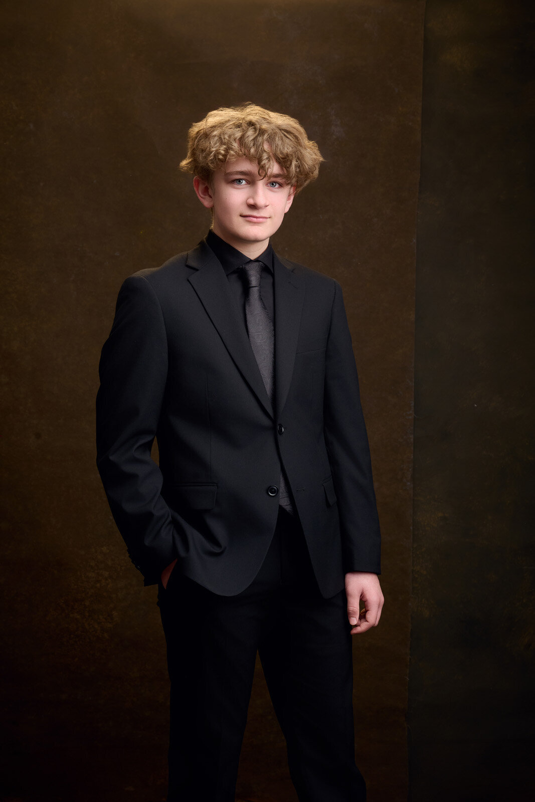 Young Man in a Suit Posing Against a Dark Studio Background-68