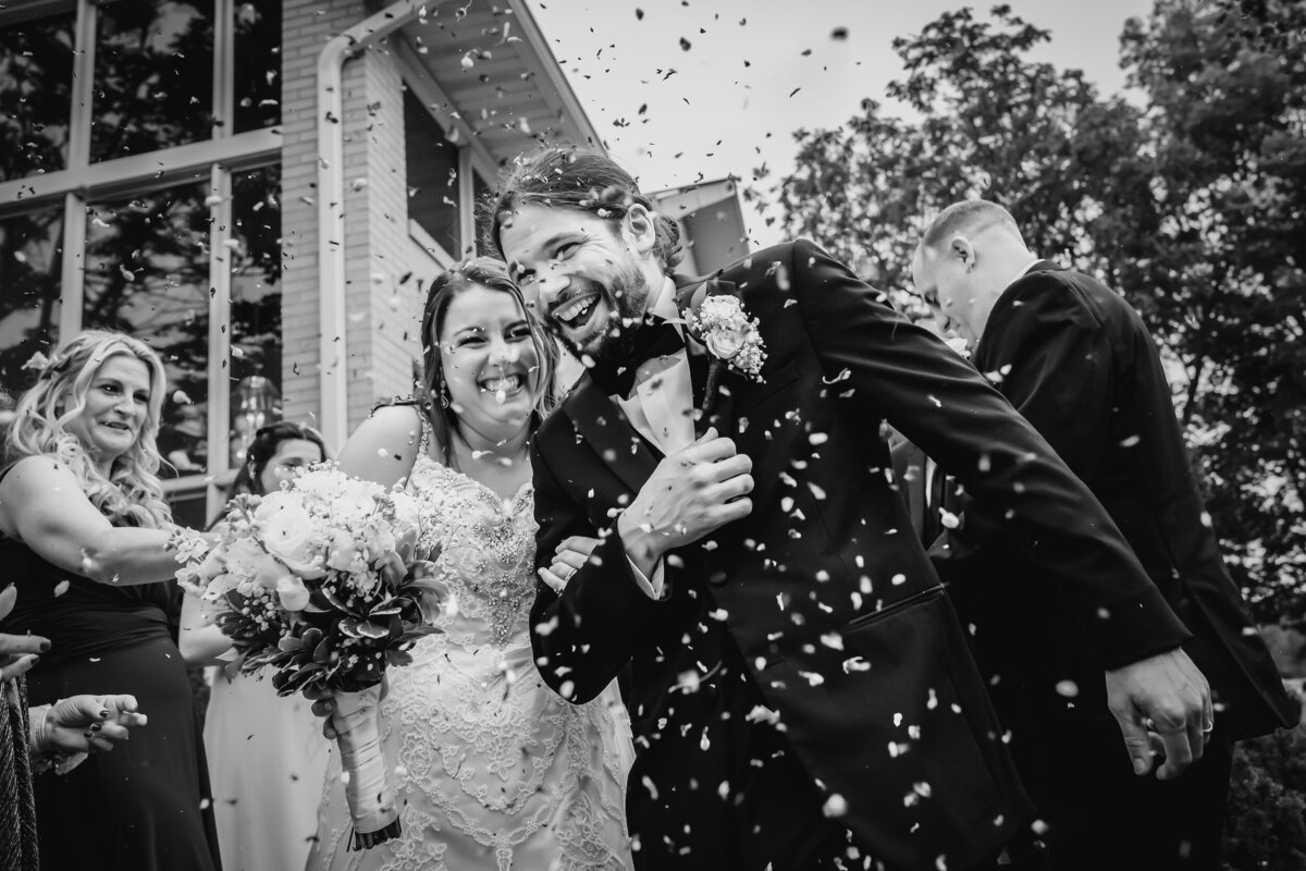 Wedding guests throw confetti  at the bride and groom after their wedding ceremony