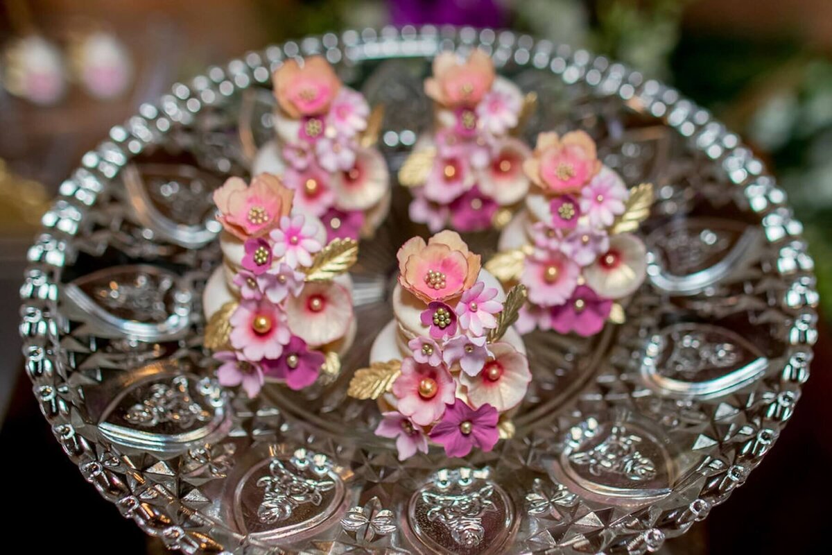 miniature iced biscuits with sugar flowers on a crystal cake stand