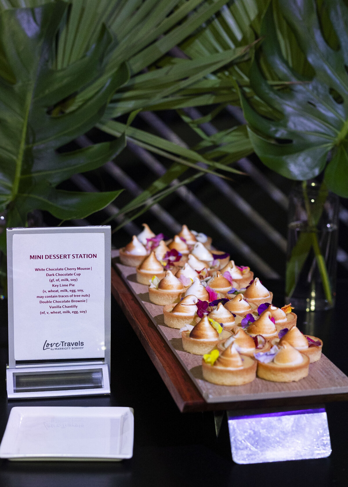 Mini desserts are arranged on a wooden serving tray.