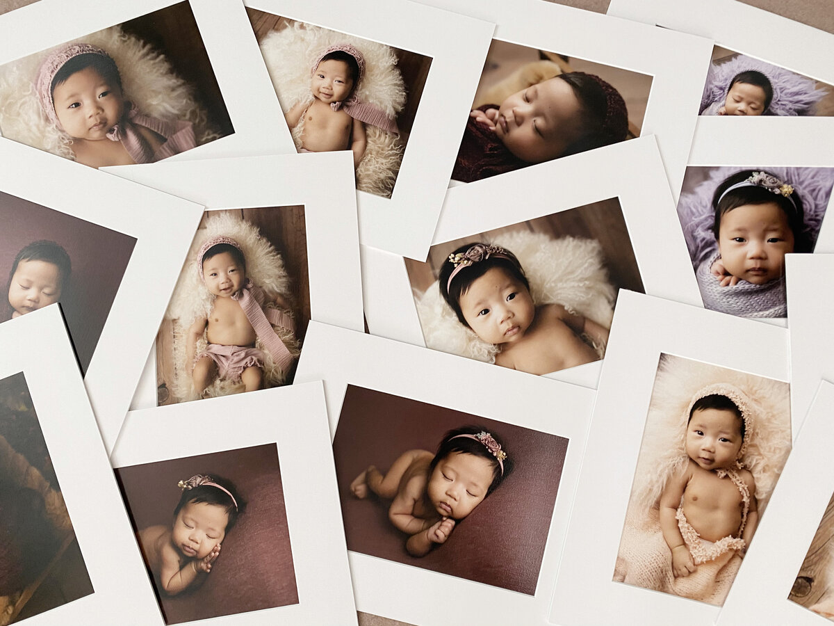 A pile of matted portraits fro,m a newborn photography session.