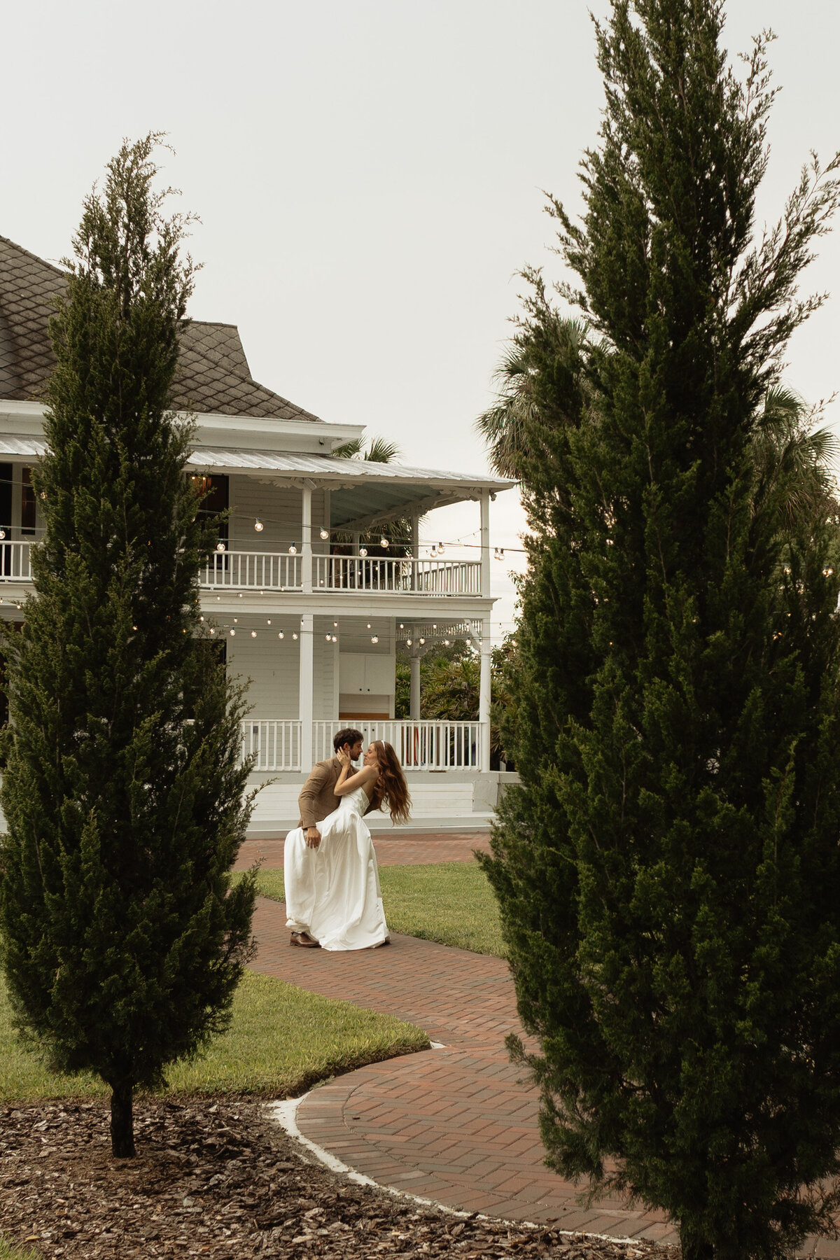 Elegant outdoor wedding surrounded by tropical greenery and historic charm at The Palm Mansion