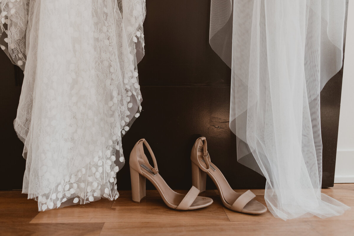 Bride's nude heels with the bottom of her dress and the bottom of her veil.