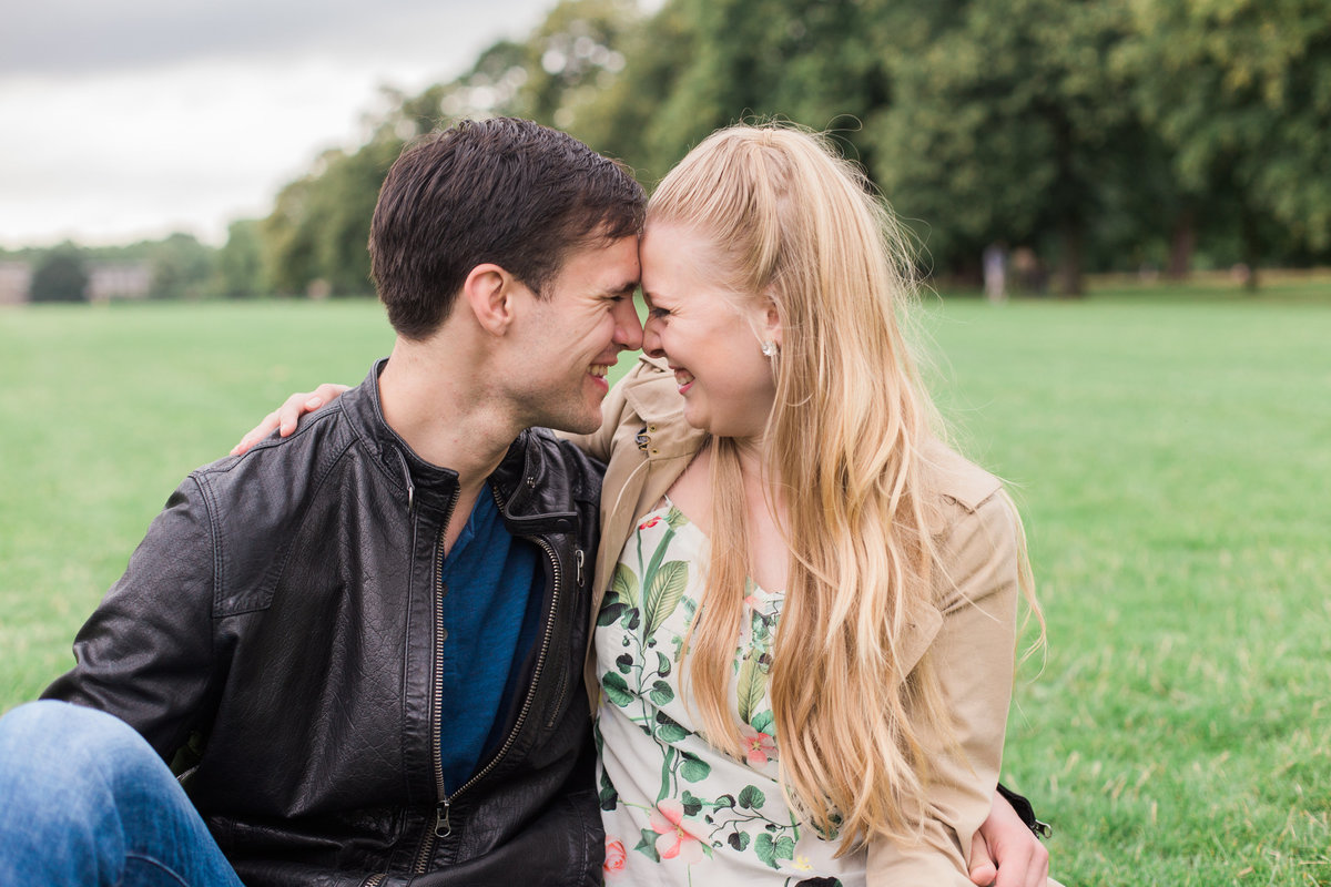 couple kissing and smiling in a field