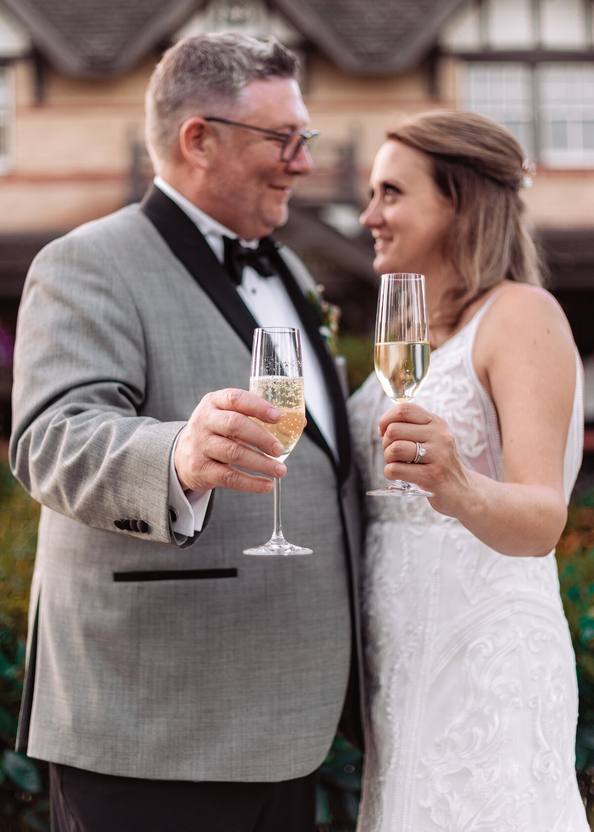 Wedding couple holds out glasses from their champagne pop