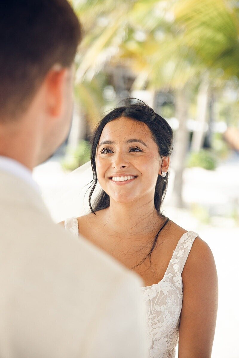 Bride smiling at groom on the beach by travel planner for destination weddings CC Vacations