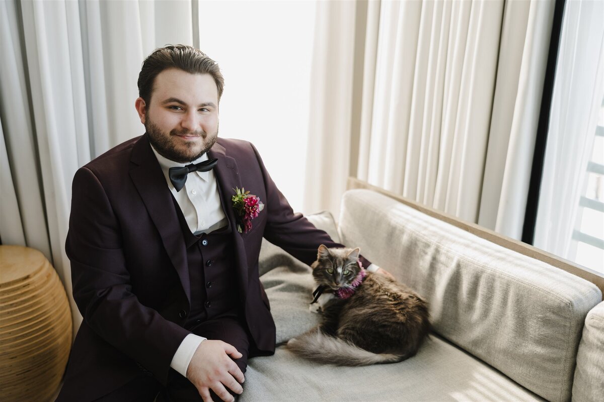Groom with his cat wearing a flower collar on his wedding day in New Jersey
