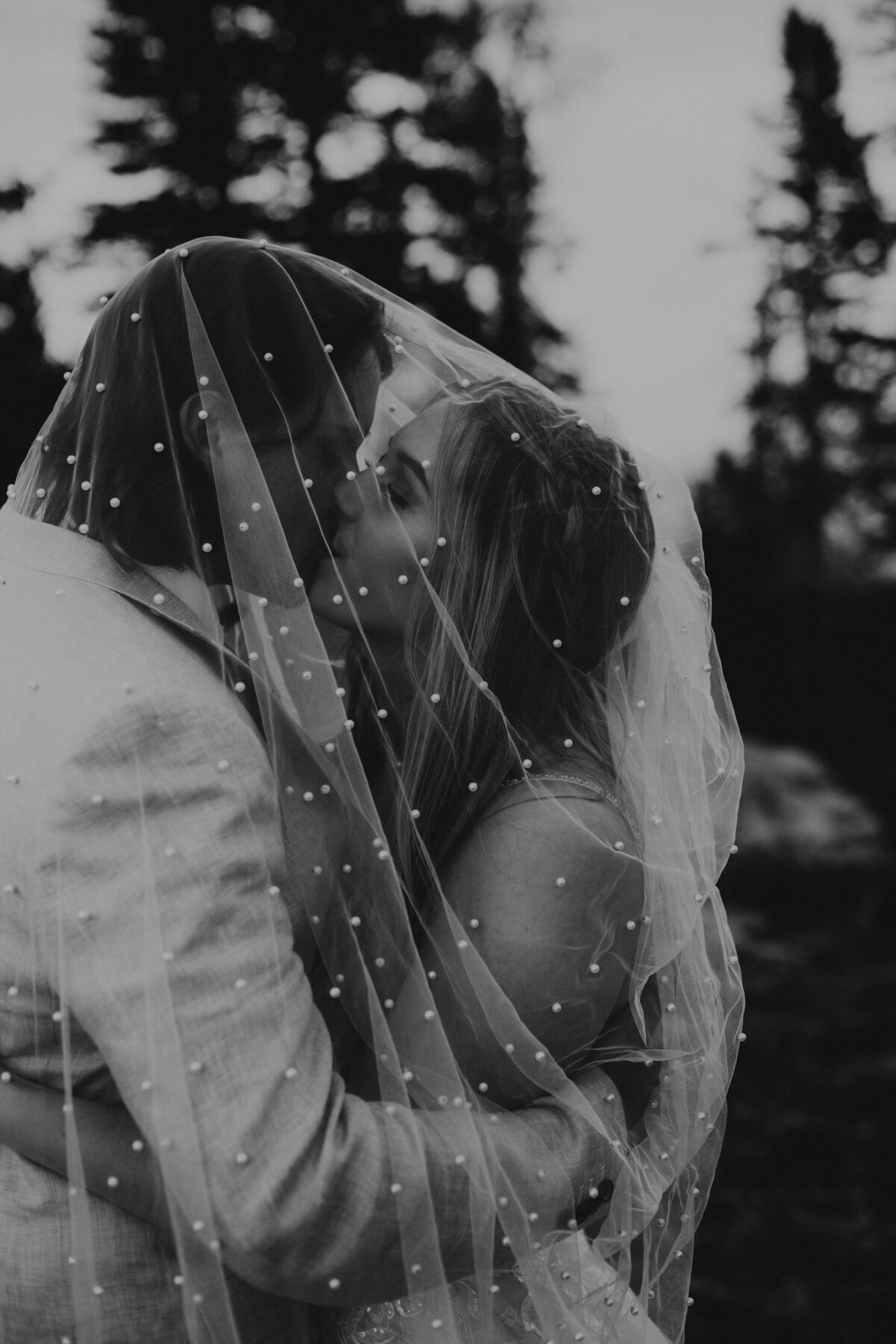 bride and groom about to kiss under her veil