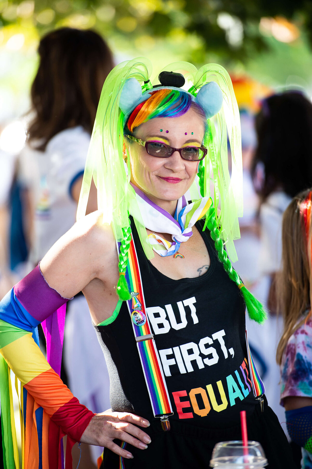 a woman with a pride wig, armbands and clothing smiling as she marches during the Tweed Canopy Growth pride parade.  Captured by Ottawa Event Photographer JEMMAN Photography COMMERCIAL