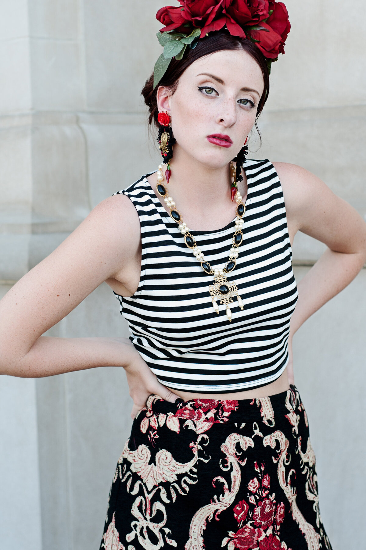 senior picture of girl in striped shirt and patterned skirt with flowers