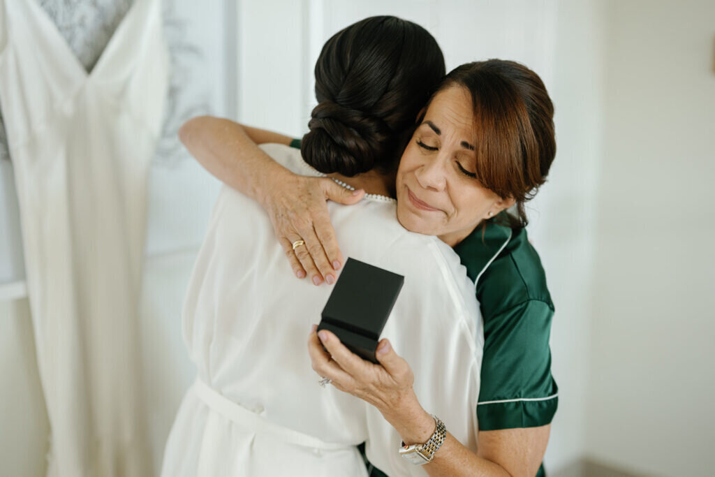 A heartfelt moment as the bride gifts her mother a meaningful present before the wedding. Captured by Florida Keys wedding photographer Claudia Amalia Photography.