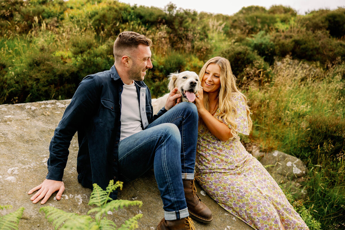 A cute couple and their dog enjoying a candid moment on their Ilkley Moor pre wedding photo shoot