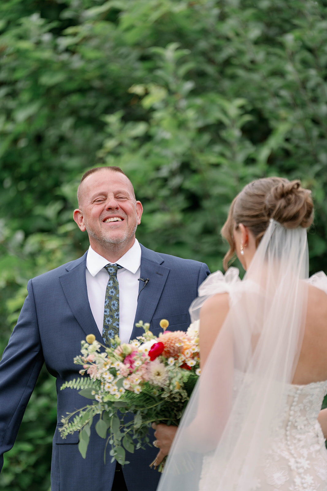 The bride’s dad reacting emotionally to seeing his daughter in her wedding dress for the first time during a heartfelt first look at Nugent Orchards in Frankfort, Michigan.