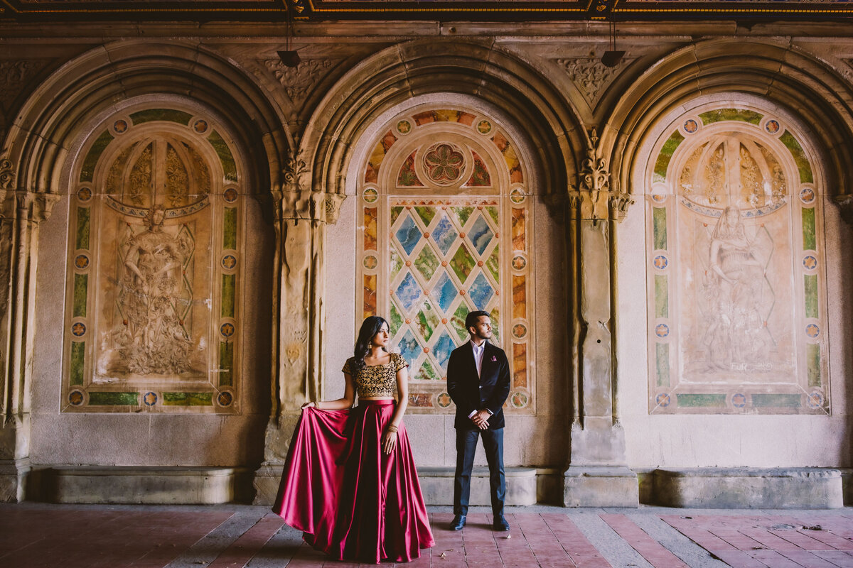 An engaged couple in indian outfit standing in front of the arches at central park bethesda terrace arcade