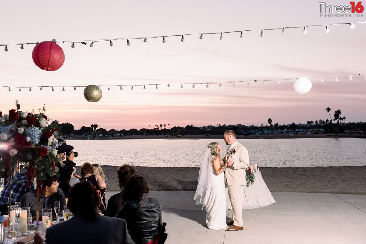 Bride and Groom share their first dance during sunset off the back bay waters at Newport Dunes