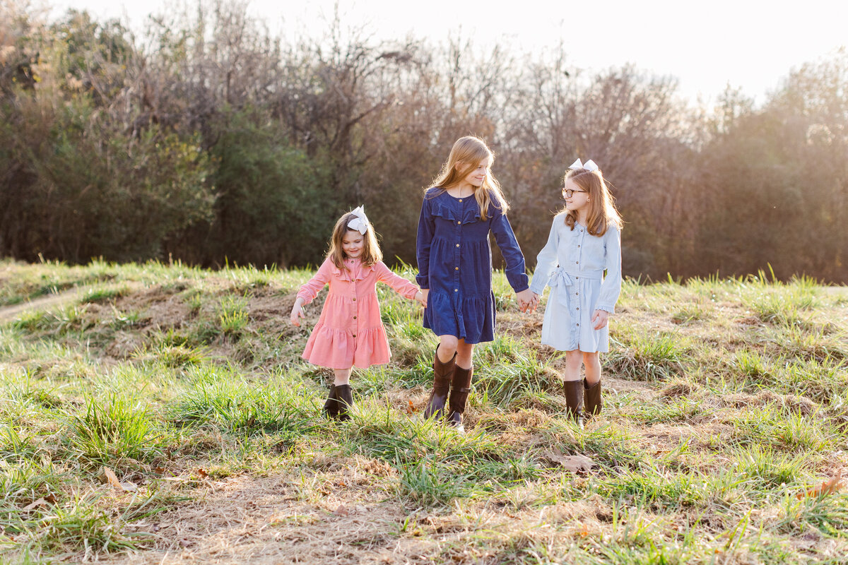 three sisters walking across a field in Georgia