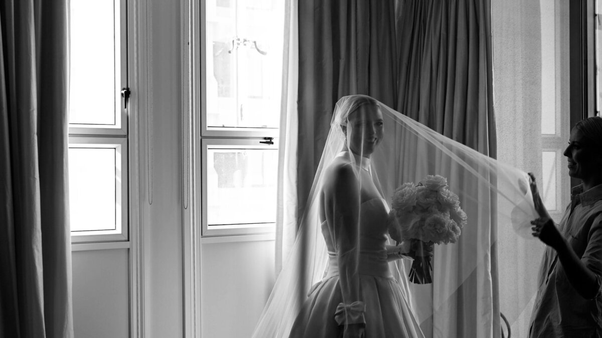 A bride has her veil adjusted in front of a grand window in Brisbane city - photographer