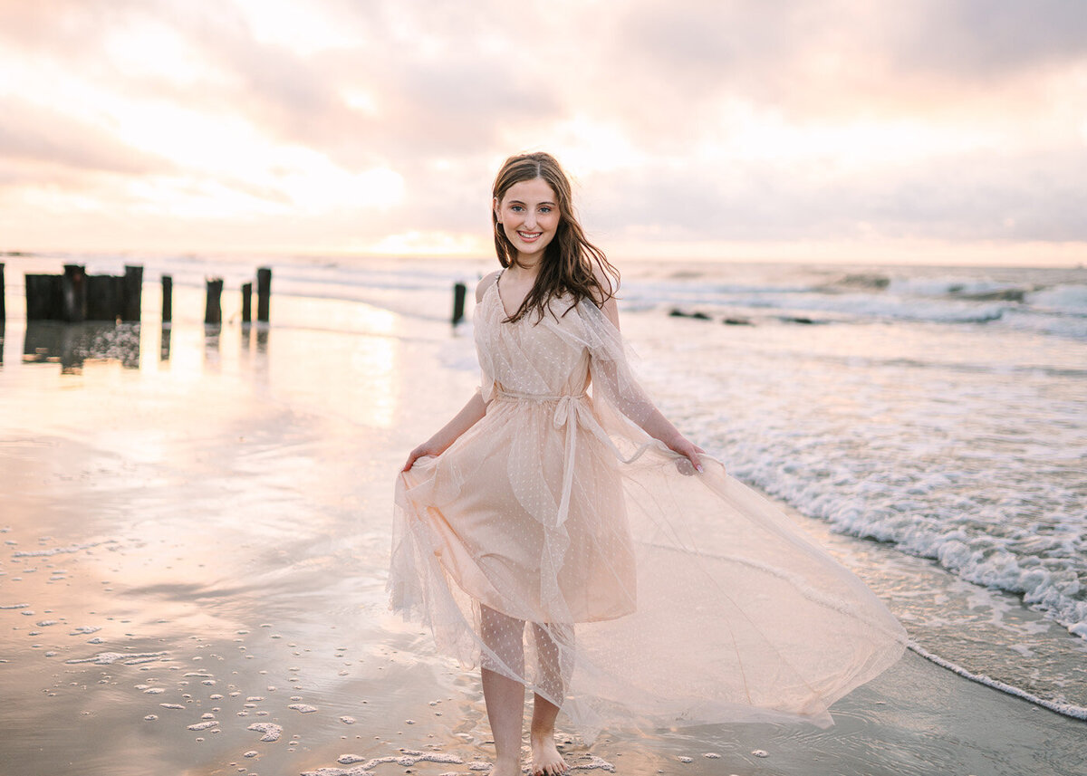These professional graduation photos capture the stunning sunset during this beach photoshoot.