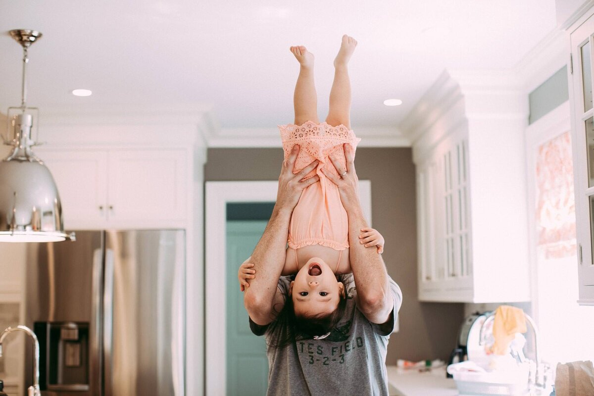 nyc family photo of toddler upside down and laughing
