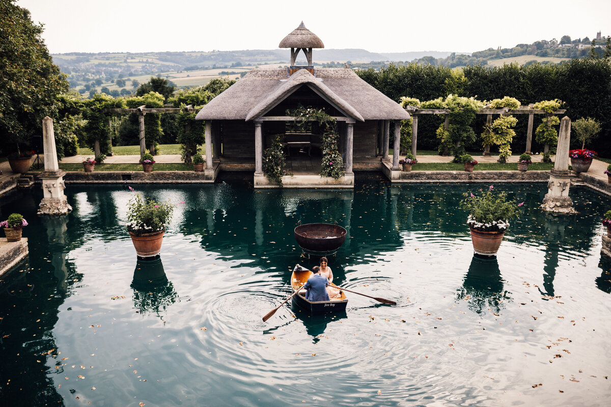 Couple in a romantic rowboat at lush outdoor wedding venue