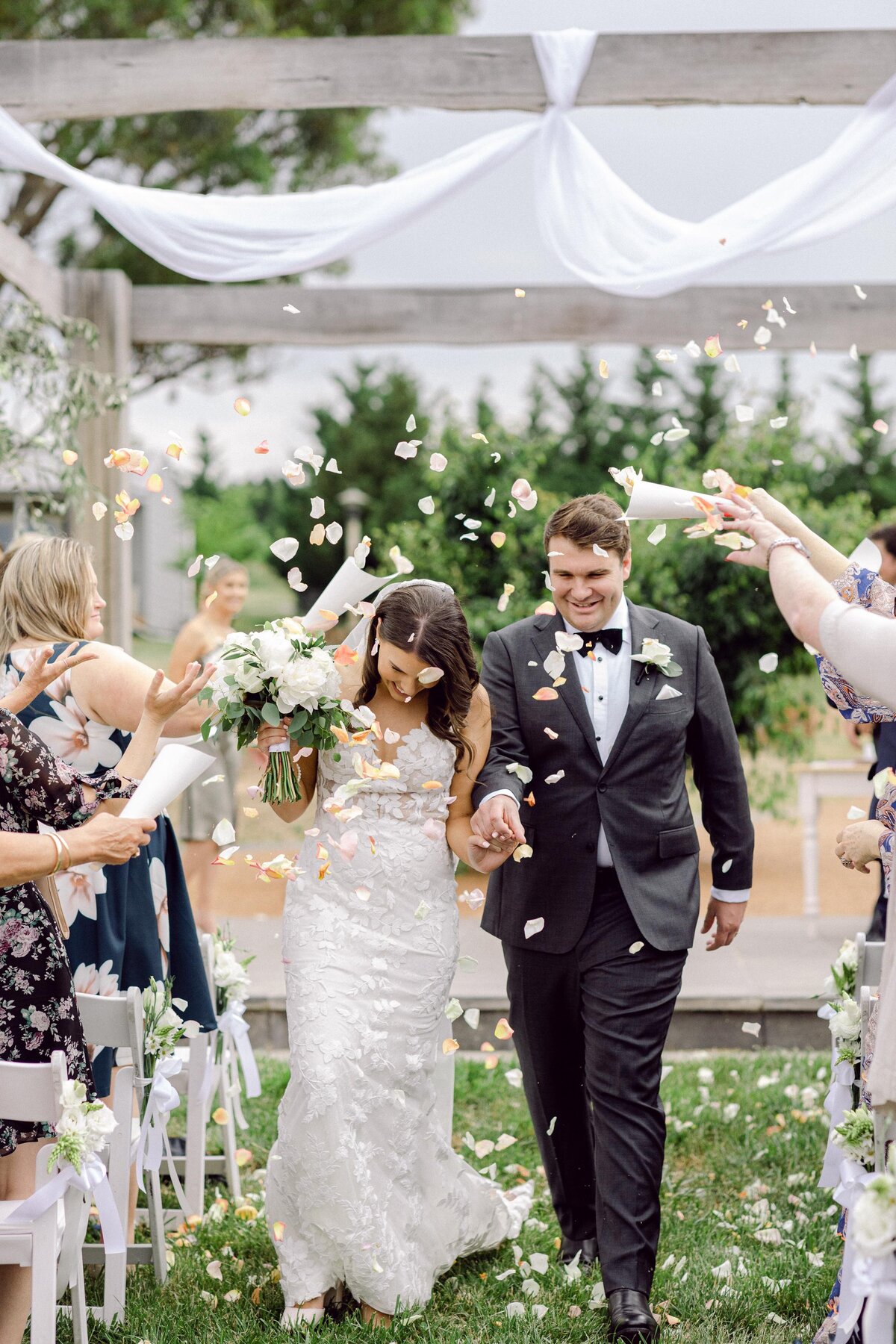 happy bride and groom and throwing petals