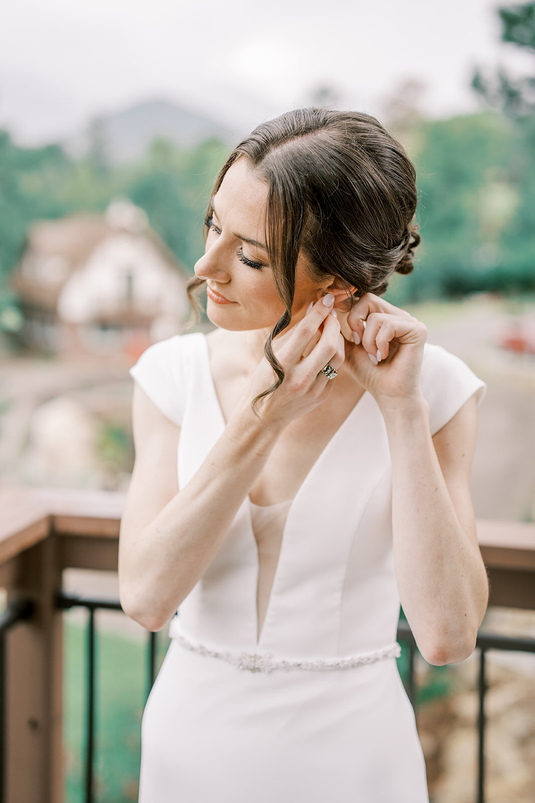 Bride puts in her earings before her wedding ceremony  at the Landing Estes Park.