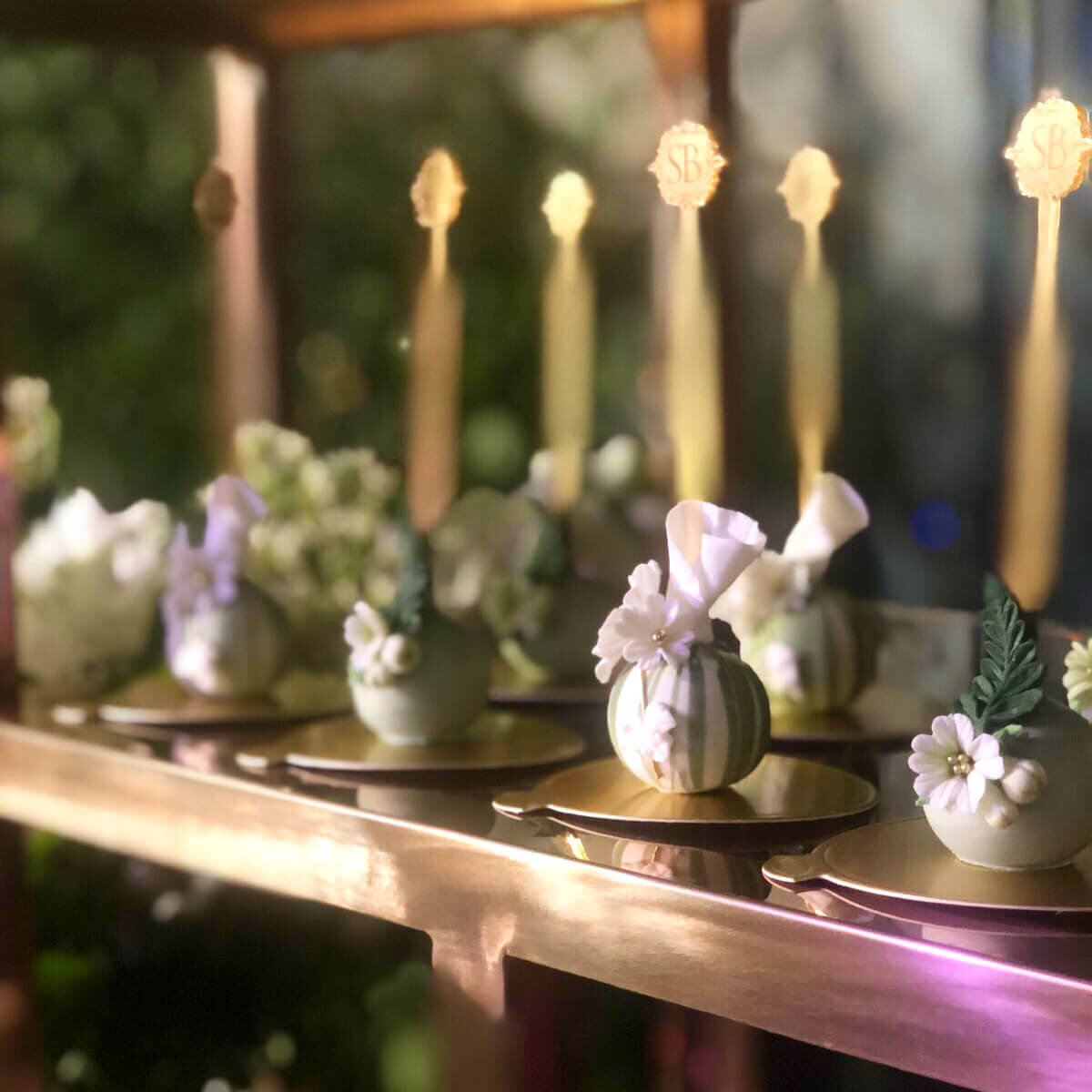 Beautiful mini desserts served on a golden disc decorated with sugar flowers