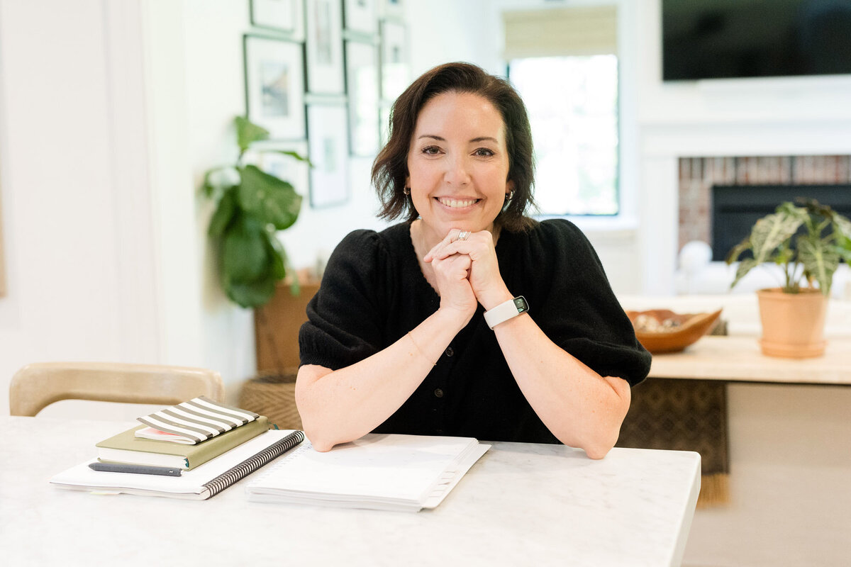 Life coach Dinah McBride smiling as she sits at her kitchen counter