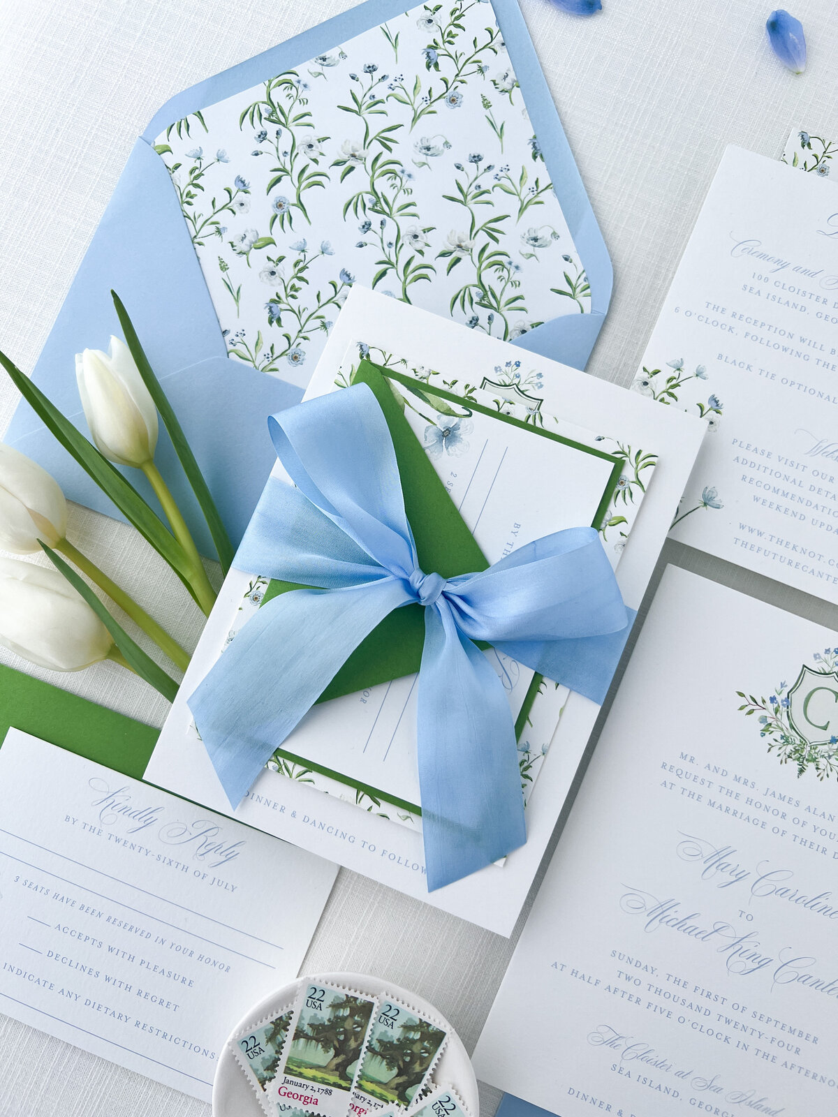 a large blue ribbon tied in a bow used to hold together wedding stationery