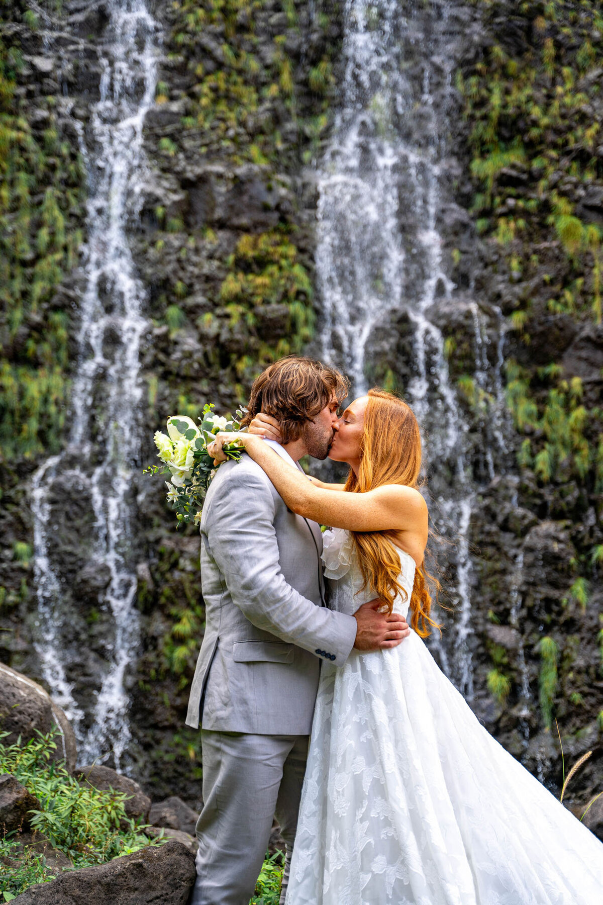 Couple kissing in front of waterfall, taken by kona hawaii wedding photographers

