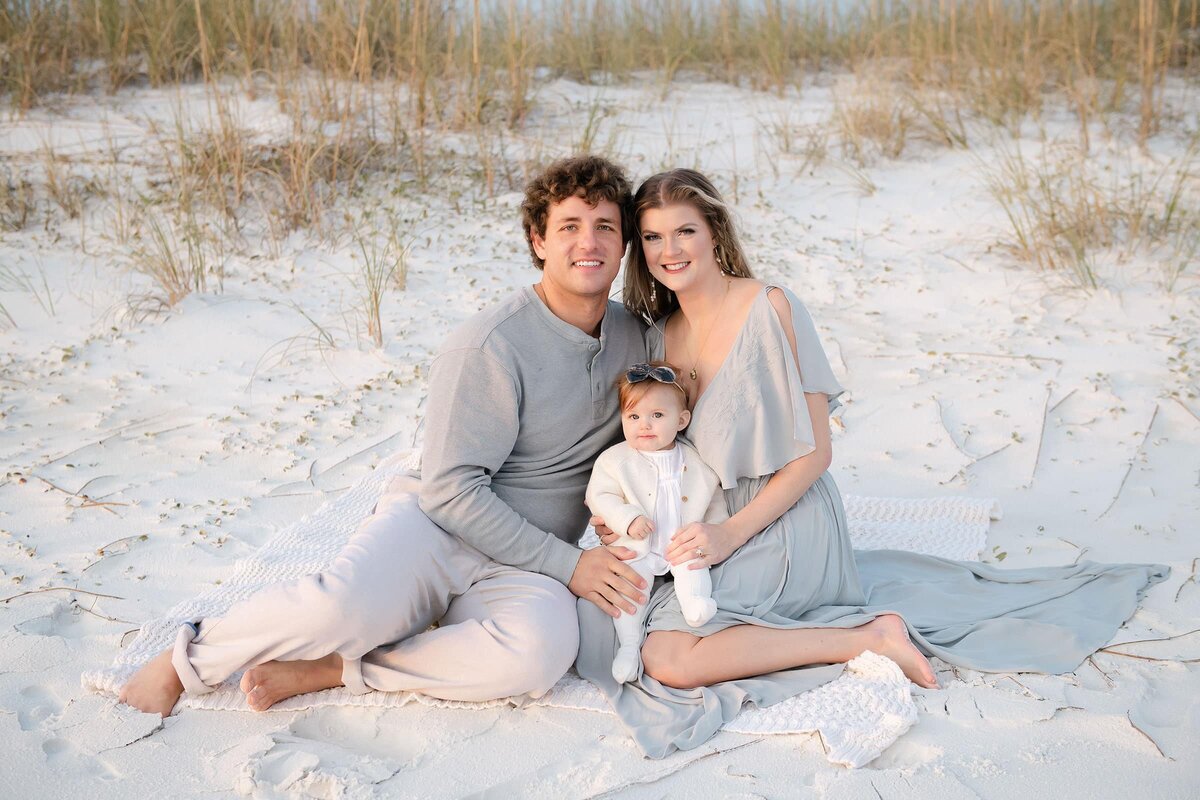 a family posing at a destin beach during photo session
