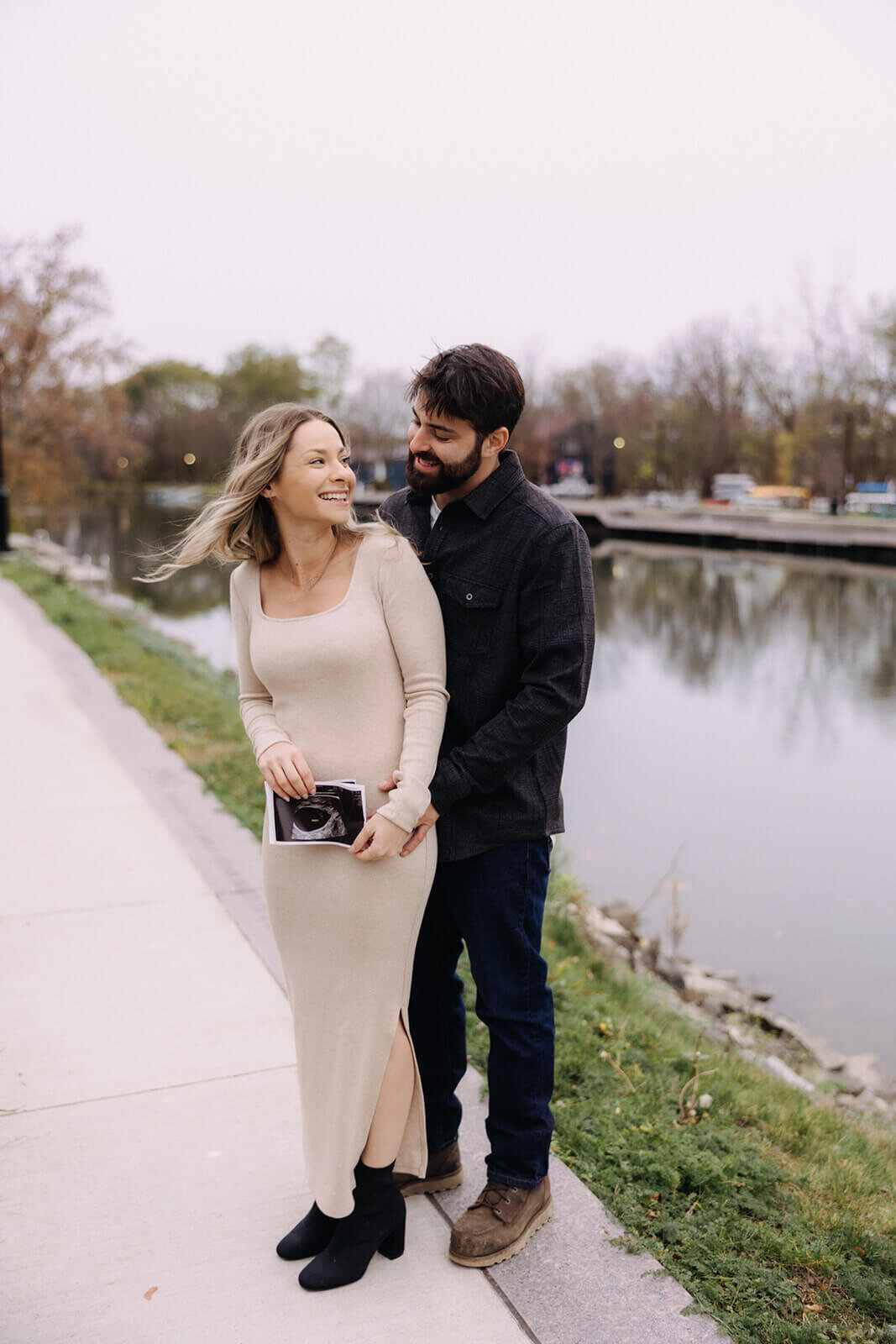 Couple standing by lake for maternity photos in Finger Lakes New York
