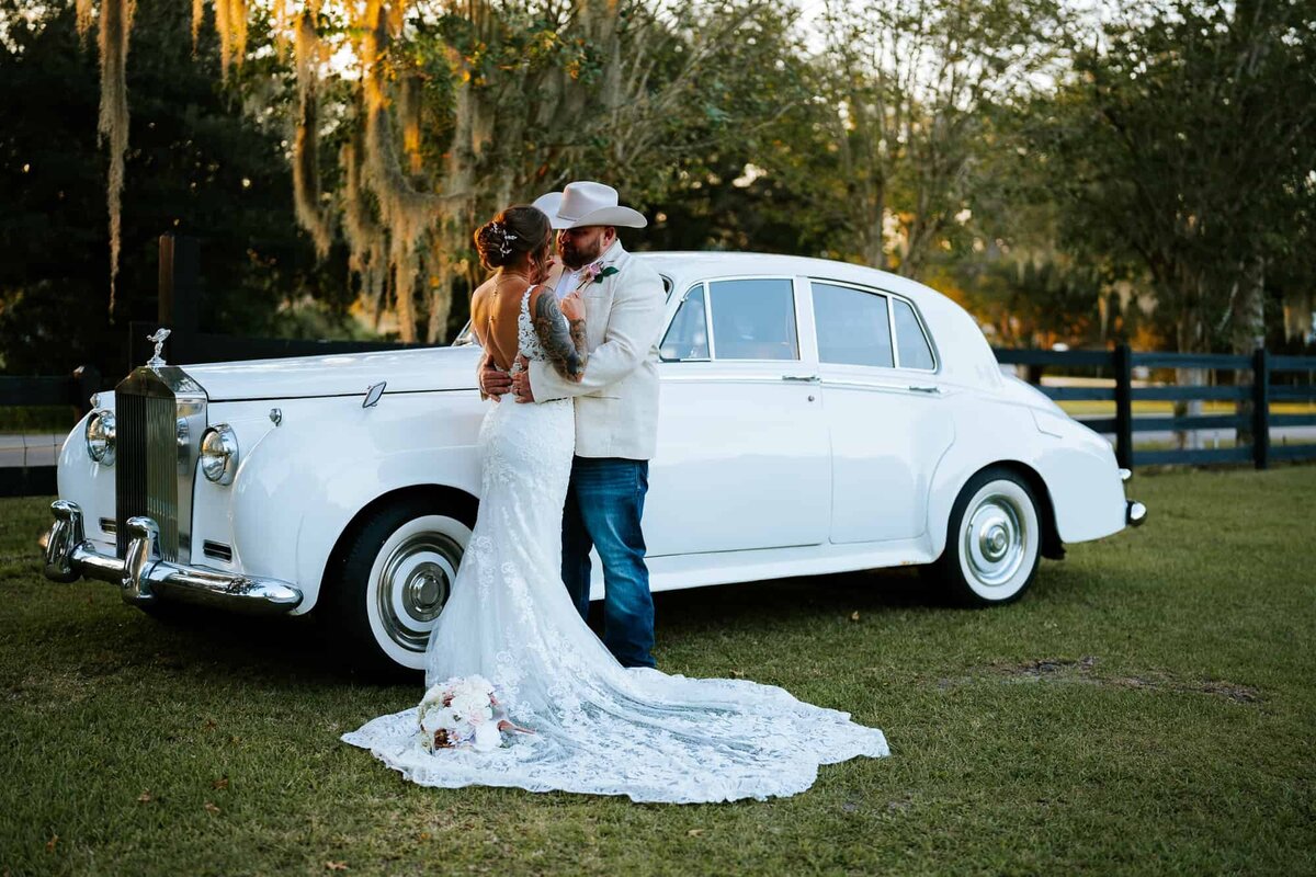 Wedding couple in love being photographed by their Ocala wedding Photographer in front of Rolls Royce