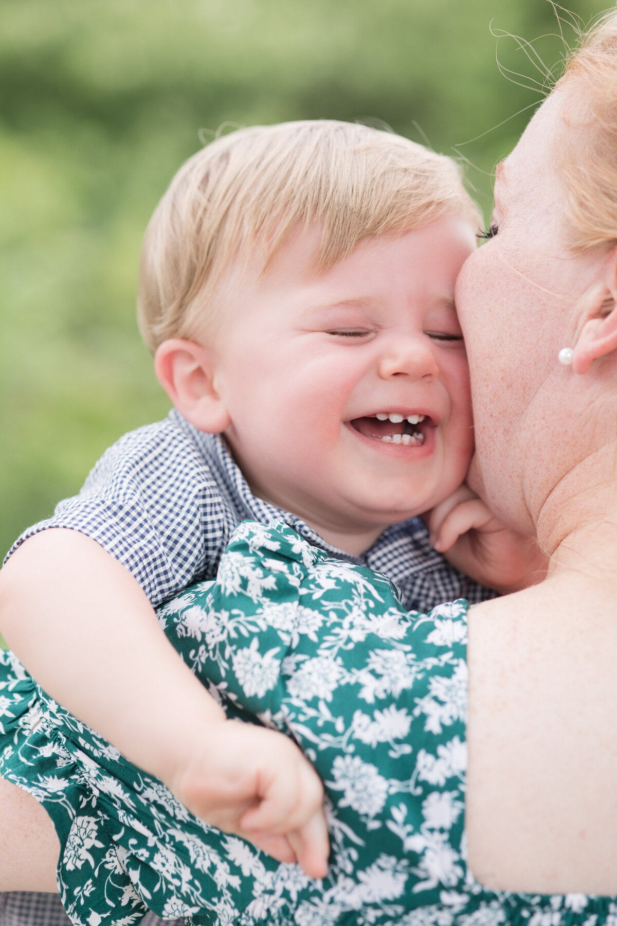 A mother holding her baby while her baby is laughing