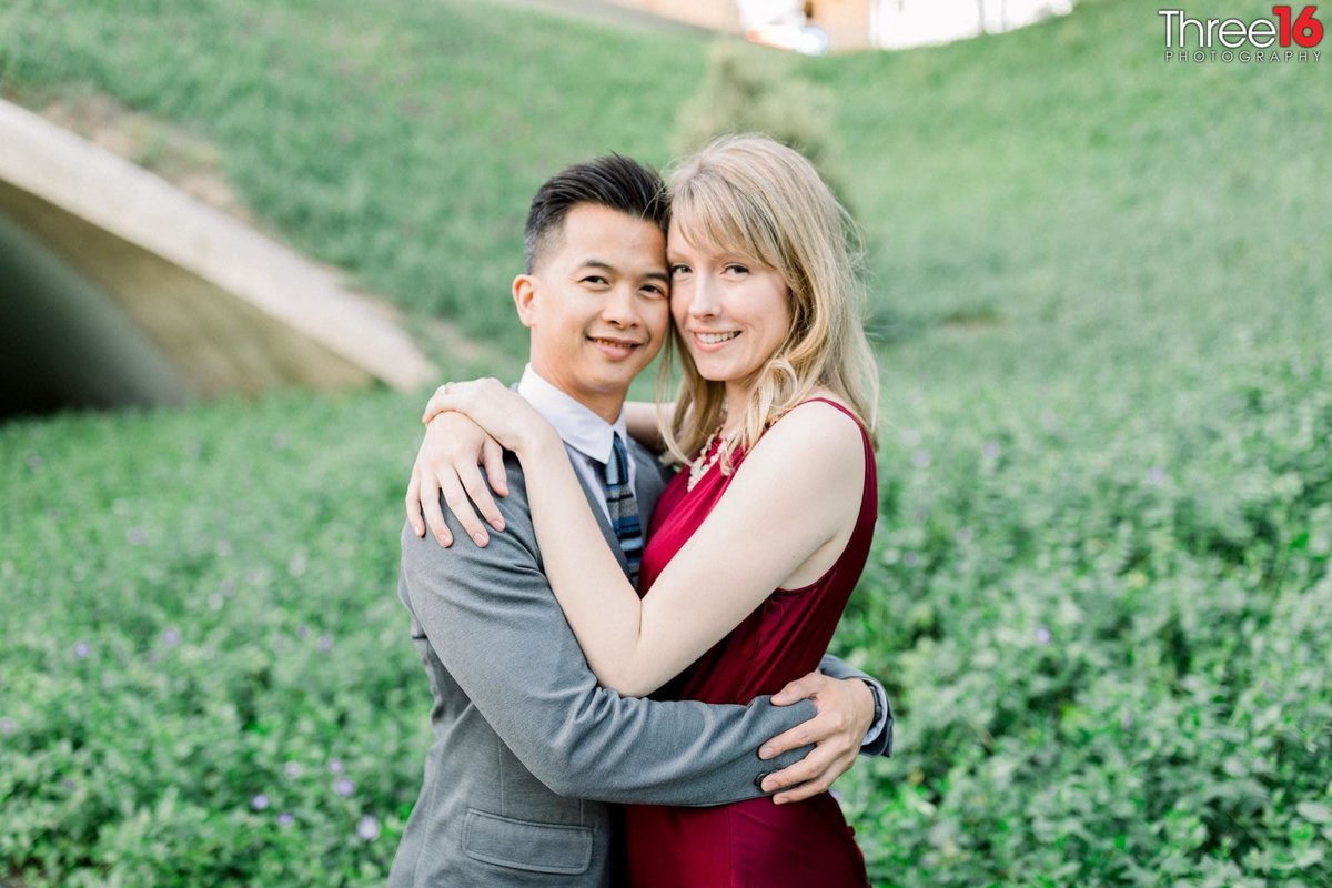 Engaged couple embrace each other in the fields of UC Irvine