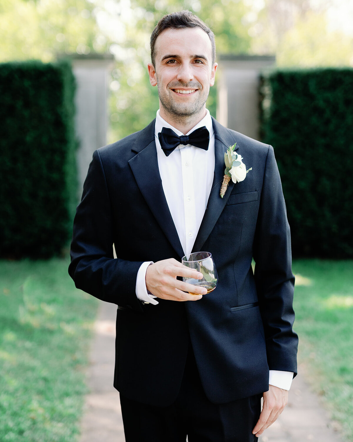 Photo of groom holding his drink before the wedding