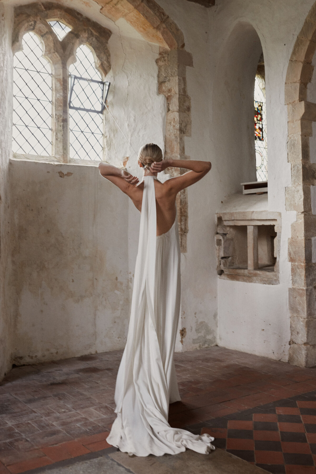 Bride wearing backless long wedding dress in silk in church