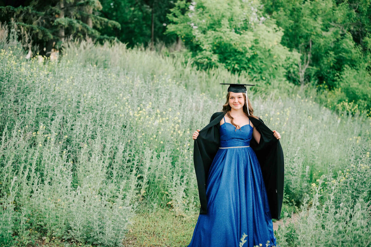 Holding grad gown open and standing with attitude. 