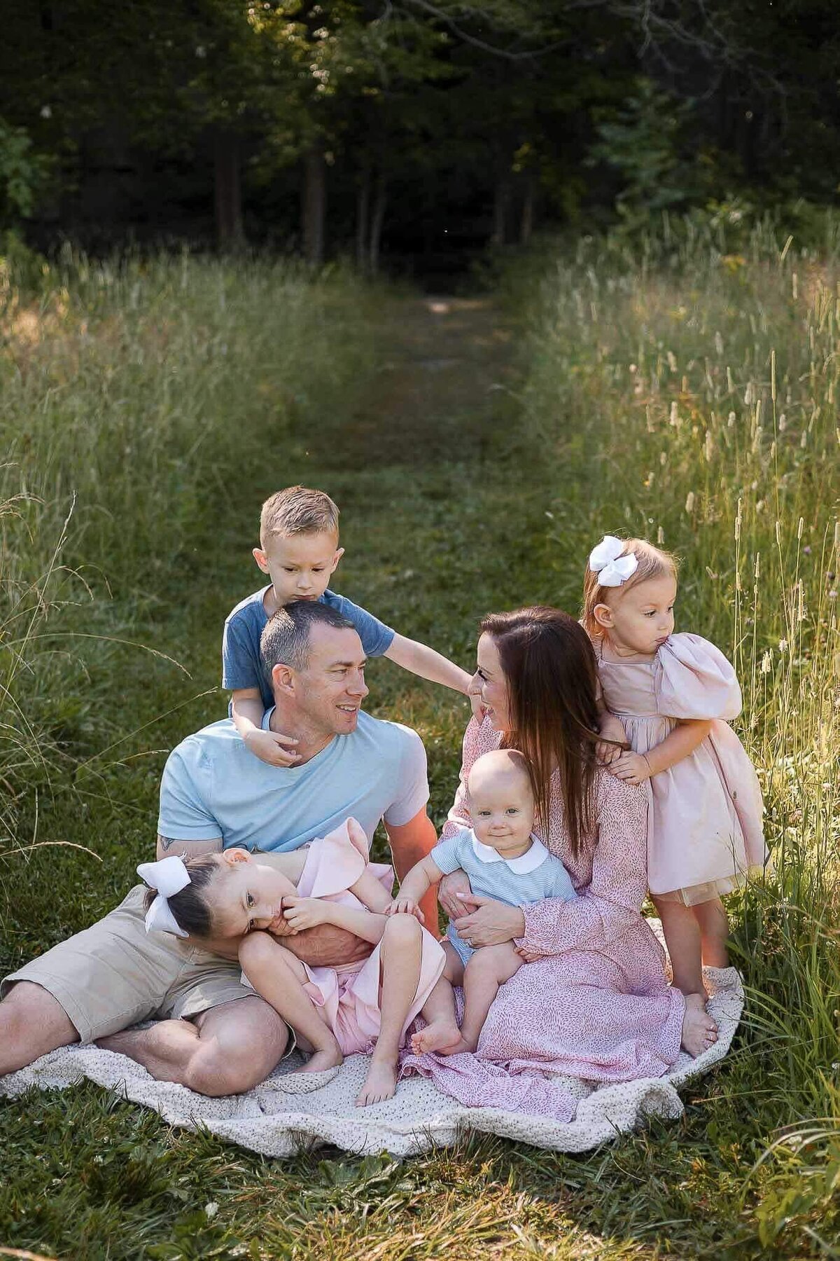 Big family snuggling on a blanket during family photography session at Huntington Reservation in Bay Village, Ohio.