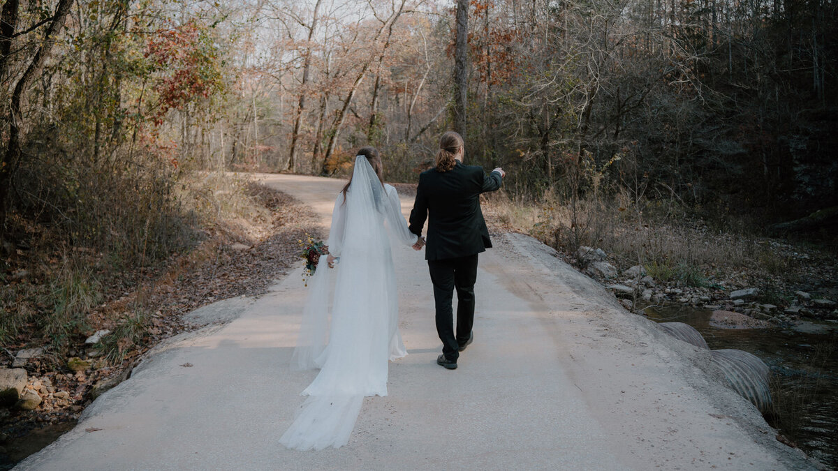 photo of bride and groom  walking down a path after their wedding